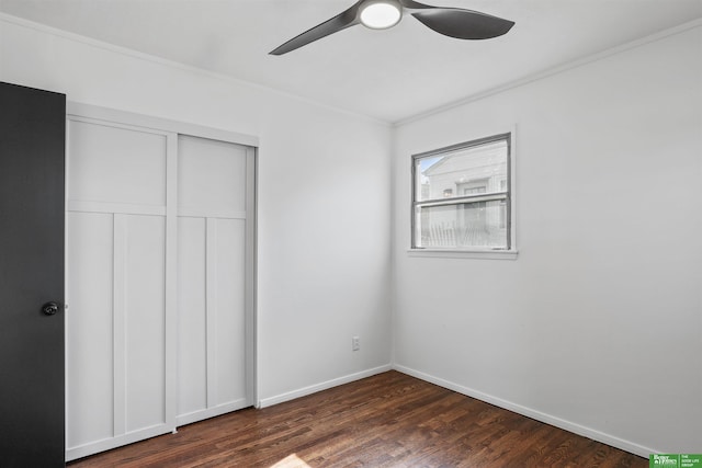 unfurnished bedroom with a ceiling fan, crown molding, baseboards, a closet, and dark wood-style floors