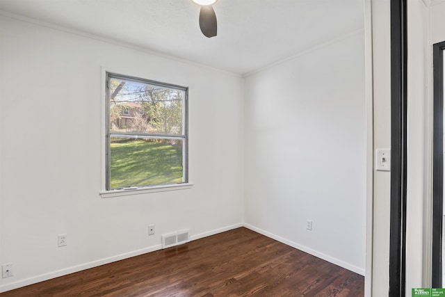 unfurnished room with crown molding, dark wood-style flooring, ceiling fan, baseboards, and visible vents