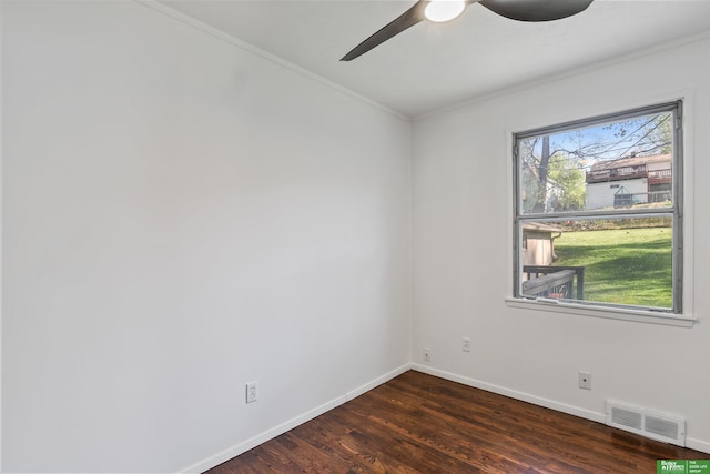 spare room with ceiling fan, visible vents, wood finished floors, baseboards, and ornamental molding