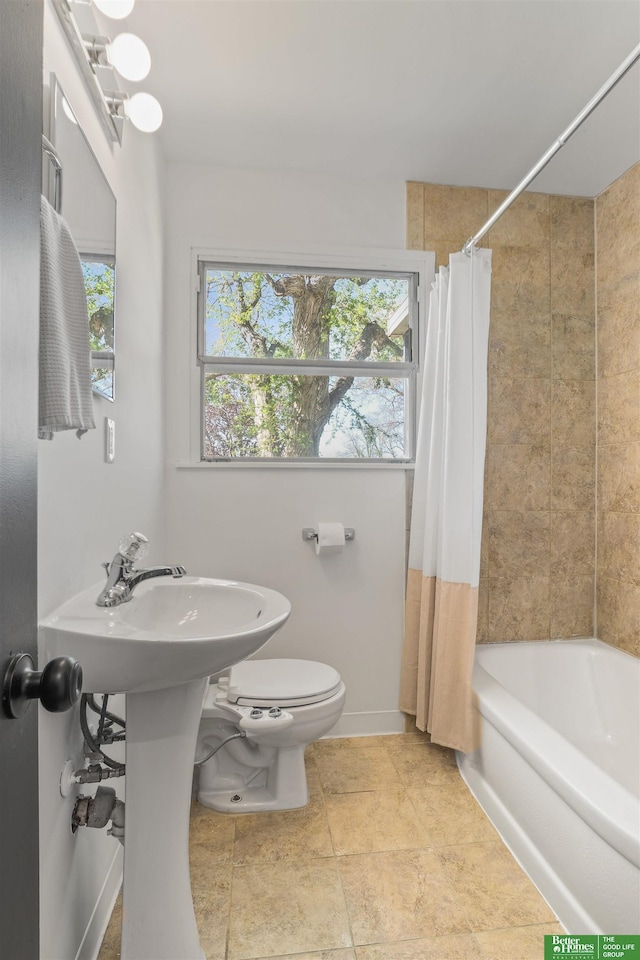 full bath featuring baseboards, shower / bath combo, and toilet