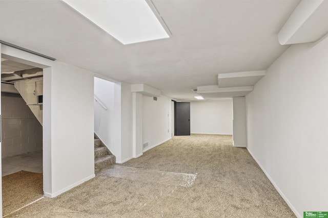 finished basement with carpet floors, baseboards, stairs, and visible vents