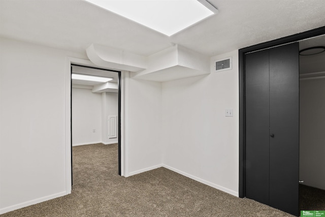 unfurnished bedroom with carpet floors, baseboards, a closet, and visible vents