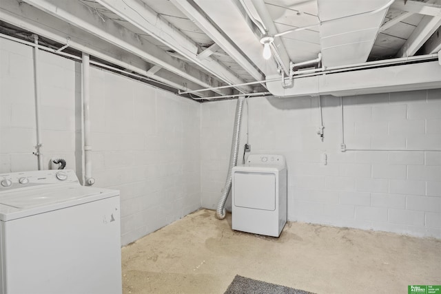 laundry area with concrete block wall, laundry area, and washing machine and dryer