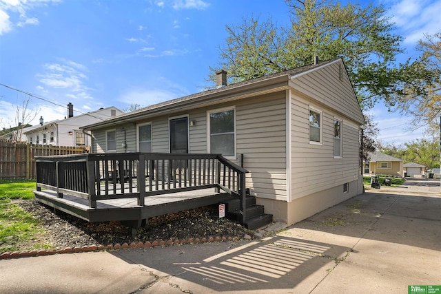exterior space with fence, a chimney, and a deck