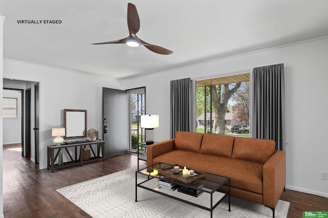 living room featuring crown molding, baseboards, ceiling fan, and wood finished floors