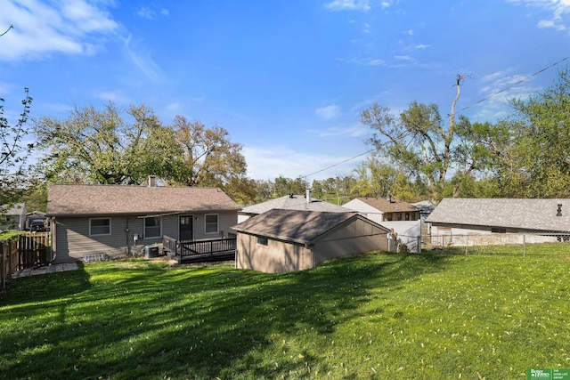 back of house featuring a lawn, a fenced backyard, and a wooden deck