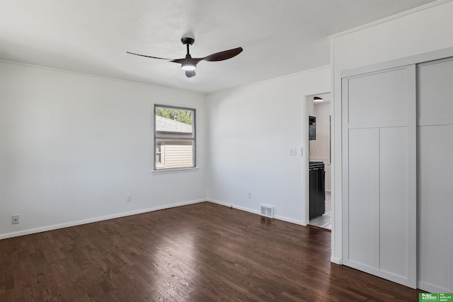 unfurnished bedroom with crown molding, baseboards, dark wood-style flooring, and visible vents