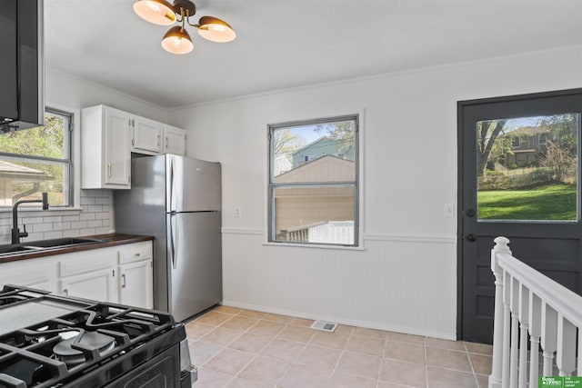 kitchen featuring freestanding refrigerator, plenty of natural light, a sink, and black range with gas stovetop