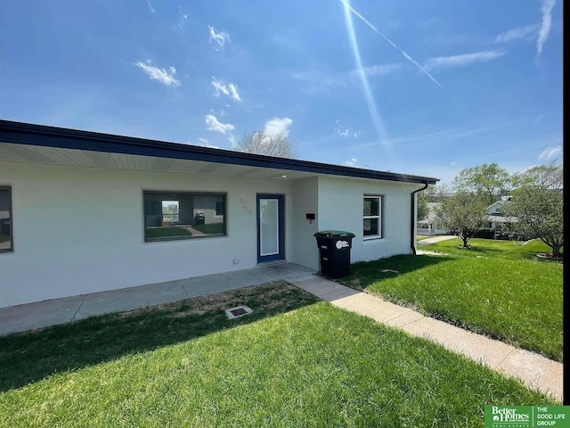 3309 S 32nd Ave, Omaha, NE 68105 - view of front facade with a front yard and stucco siding