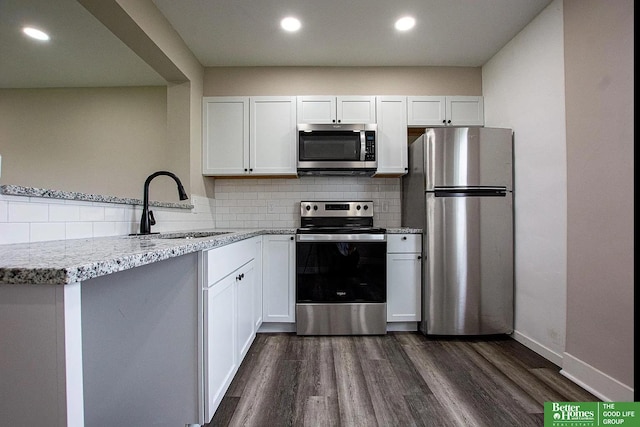 3309 S 32nd Ave, Omaha, NE 68105 - kitchen with decorative backsplash, a sink, dark wood-style floors, stainless steel appliances, and white cabinetry