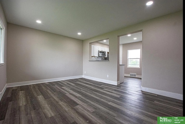 3309 S 32nd Ave, Omaha, NE 68105 - unfurnished living room featuring dark wood-type flooring, recessed lighting, and visible vents