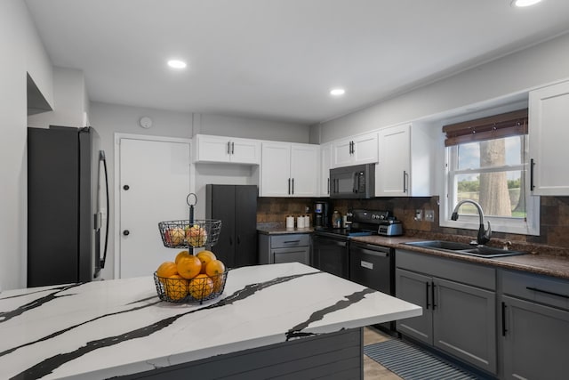 kitchen with recessed lighting, a sink, and black appliances