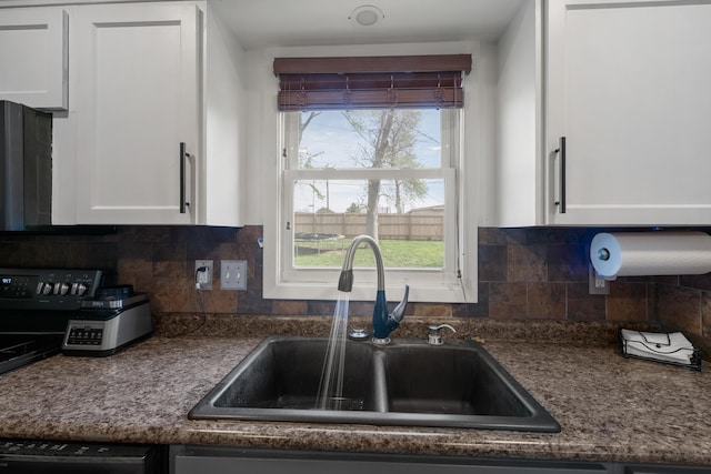 kitchen featuring a sink, white cabinetry, dishwasher, and decorative backsplash
