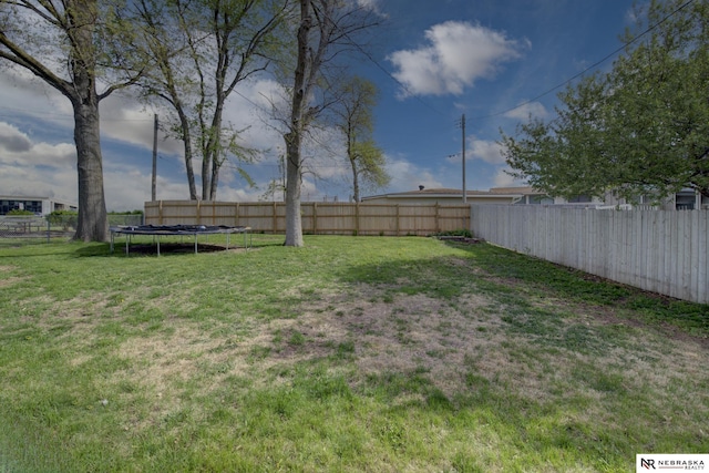 view of yard featuring a fenced backyard and a trampoline