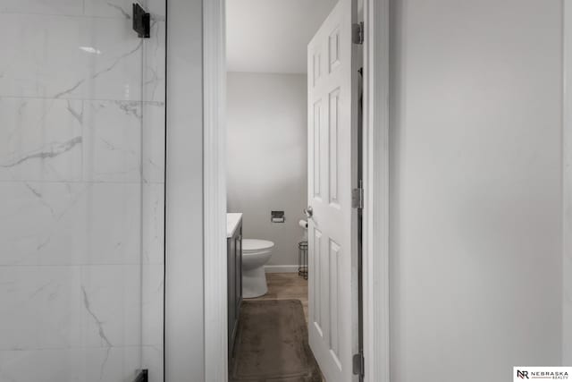 bathroom featuring vanity, baseboards, and toilet