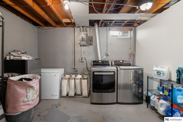clothes washing area featuring laundry area, washing machine and dryer, and electric panel