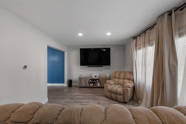 living area featuring baseboards, light wood-type flooring, and recessed lighting