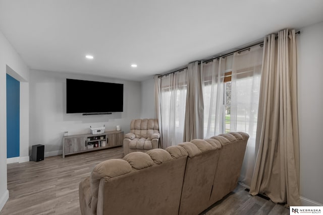 living room featuring baseboards, recessed lighting, and wood finished floors
