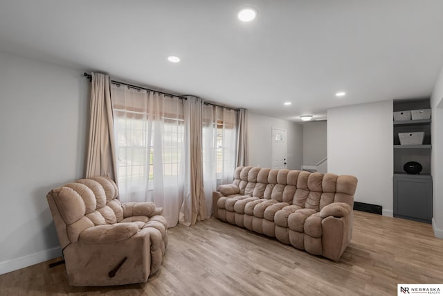living room with recessed lighting, light wood-style flooring, baseboards, and visible vents