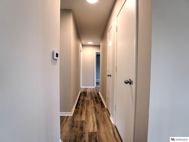 hallway with baseboards, recessed lighting, and wood finished floors