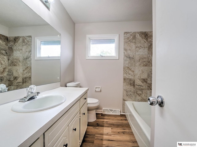 full bath featuring visible vents, wood finished floors, toilet, and vanity