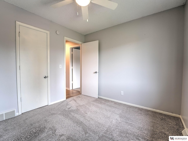 unfurnished bedroom with visible vents, carpet flooring, baseboards, and ceiling fan