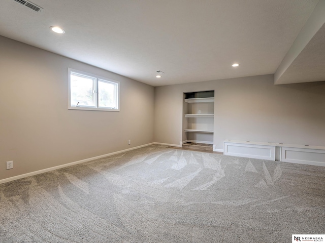 carpeted empty room featuring built in features, baseboards, recessed lighting, and visible vents