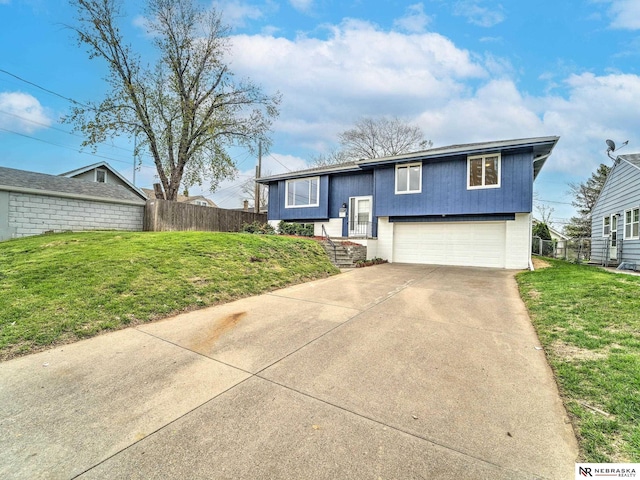 bi-level home with fence, driveway, a front yard, and a garage