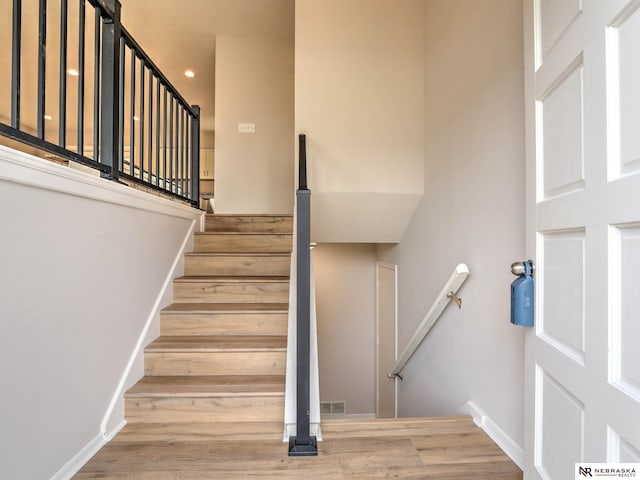 staircase with recessed lighting, baseboards, visible vents, and wood finished floors