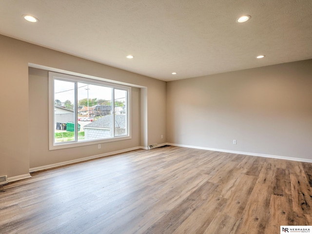 unfurnished room with recessed lighting, baseboards, and light wood-style flooring