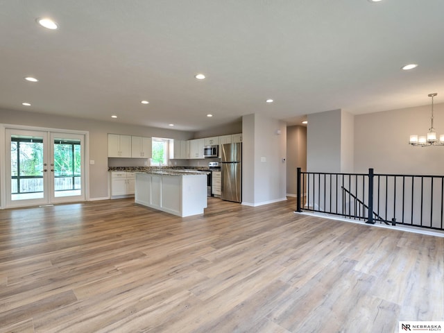 kitchen with recessed lighting, open floor plan, appliances with stainless steel finishes, and white cabinets