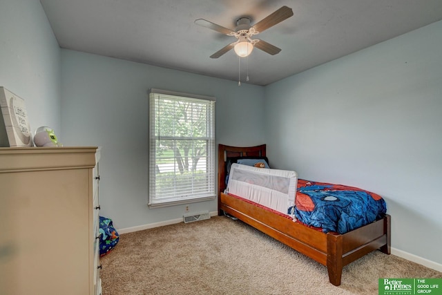 carpeted bedroom with baseboards, a ceiling fan, and visible vents
