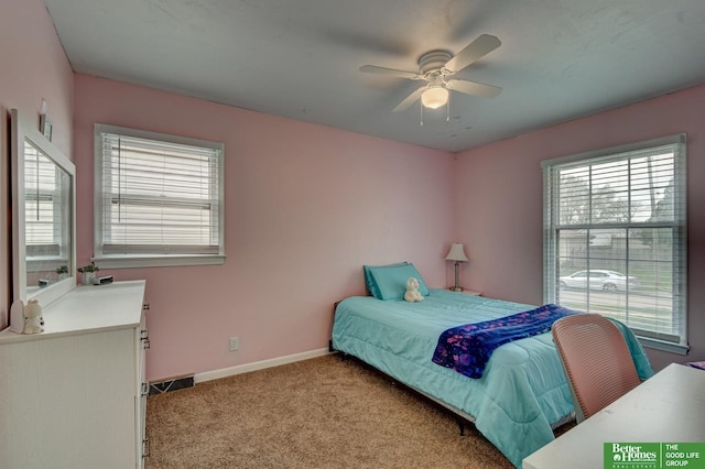 bedroom with baseboards, light colored carpet, ceiling fan, and visible vents