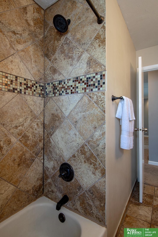 bathroom featuring baseboards and  shower combination