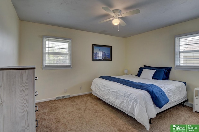 carpeted bedroom featuring baseboards, a ceiling fan, and visible vents