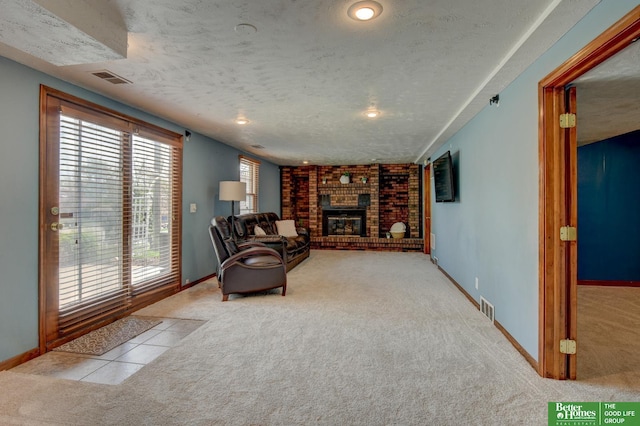 living room with carpet floors, a textured ceiling, visible vents, and a fireplace