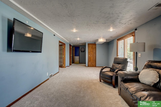 living area featuring carpet flooring, a textured ceiling, baseboards, and visible vents