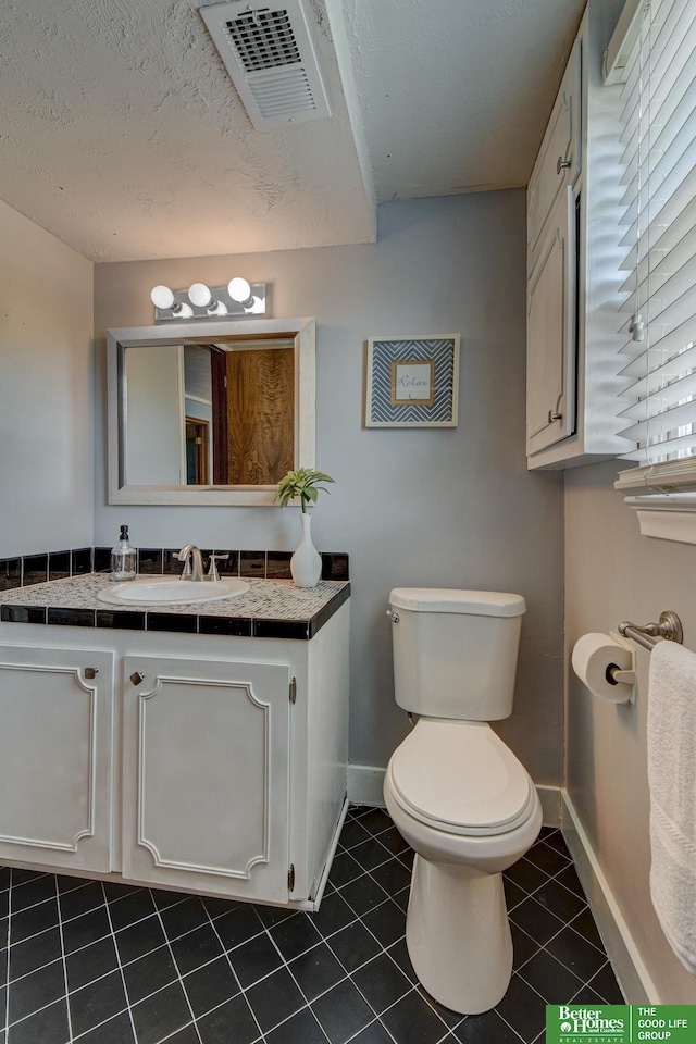 half bathroom featuring baseboards, vanity, toilet, and visible vents