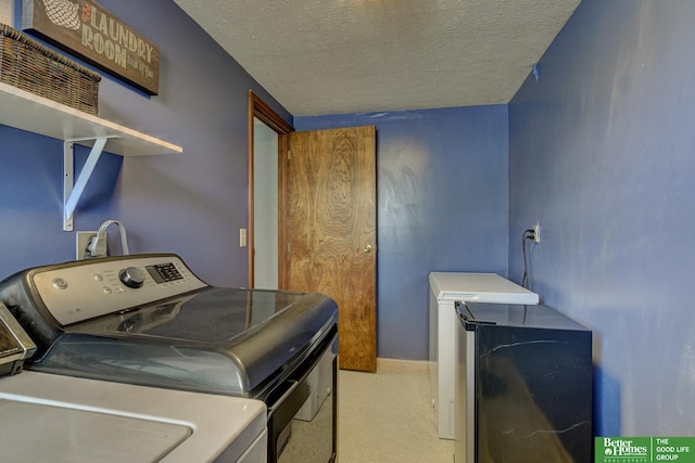 laundry area with laundry area, washer and clothes dryer, carpet, and a textured ceiling