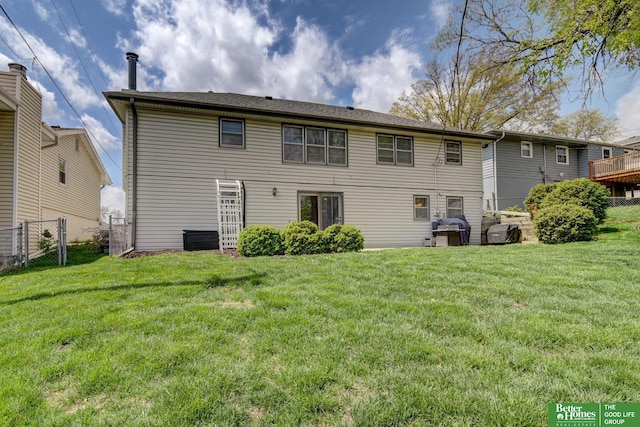 rear view of property with fence and a yard