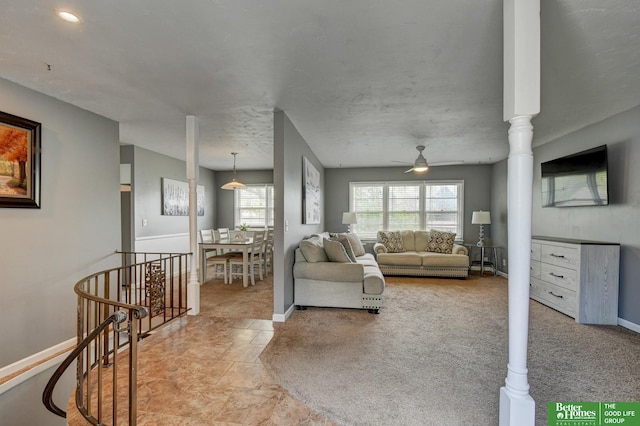living room featuring a ceiling fan and baseboards