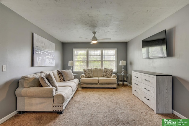 living area featuring baseboards, ceiling fan, and light colored carpet