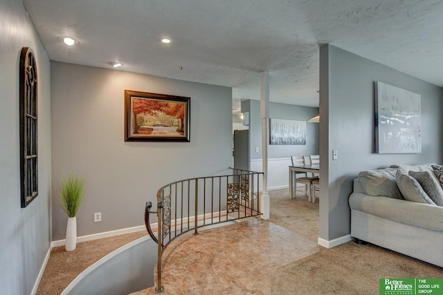 interior space featuring recessed lighting, baseboards, an upstairs landing, and carpet