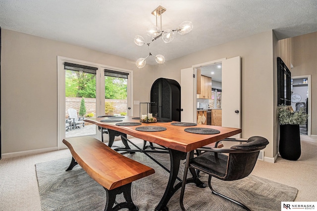 dining space with an inviting chandelier, baseboards, and light carpet