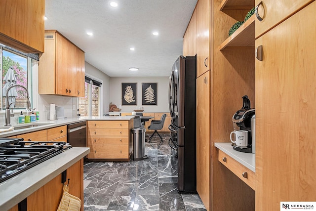 kitchen with open shelves, freestanding refrigerator, recessed lighting, light countertops, and a sink