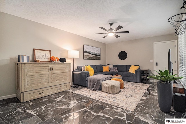 living room featuring baseboards, a ceiling fan, and marble finish floor