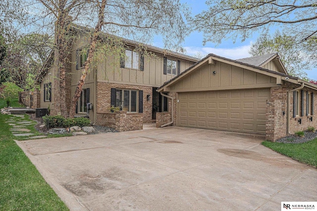 view of front of property featuring an attached garage, central AC, brick siding, board and batten siding, and driveway