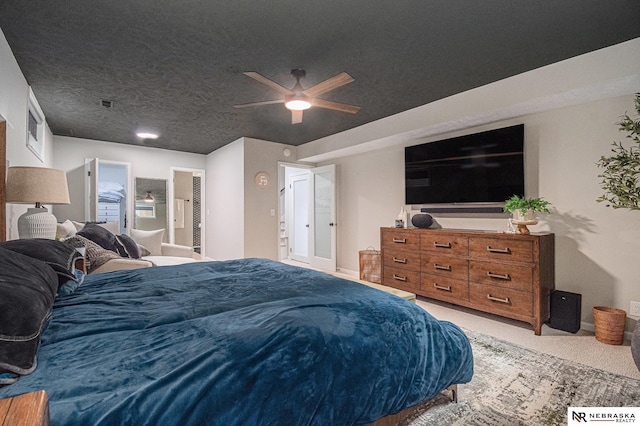 bedroom with ceiling fan, ensuite bathroom, visible vents, and light colored carpet