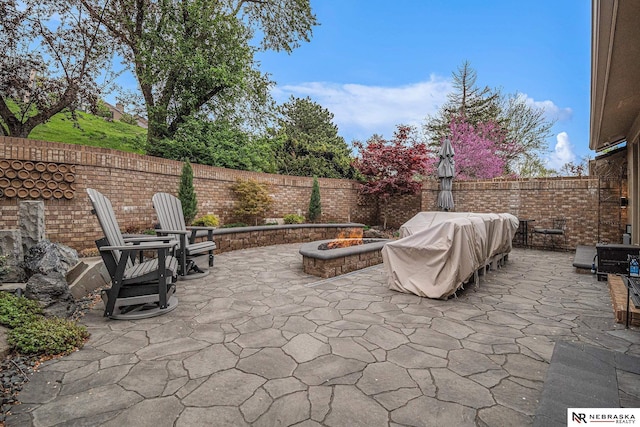 view of patio / terrace with grilling area, a fire pit, and a fenced backyard
