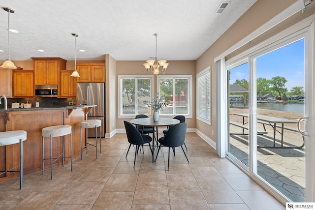 S-1007 Shady Ln, Fremont, NE 68025 - dining room featuring baseboards, a chandelier, plenty of natural light, recessed lighting, and light tile patterned flooring